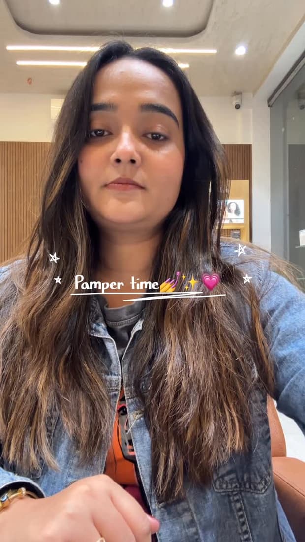 A client filming herself in the salon, hair worn long and loose, captioned Pamper time.