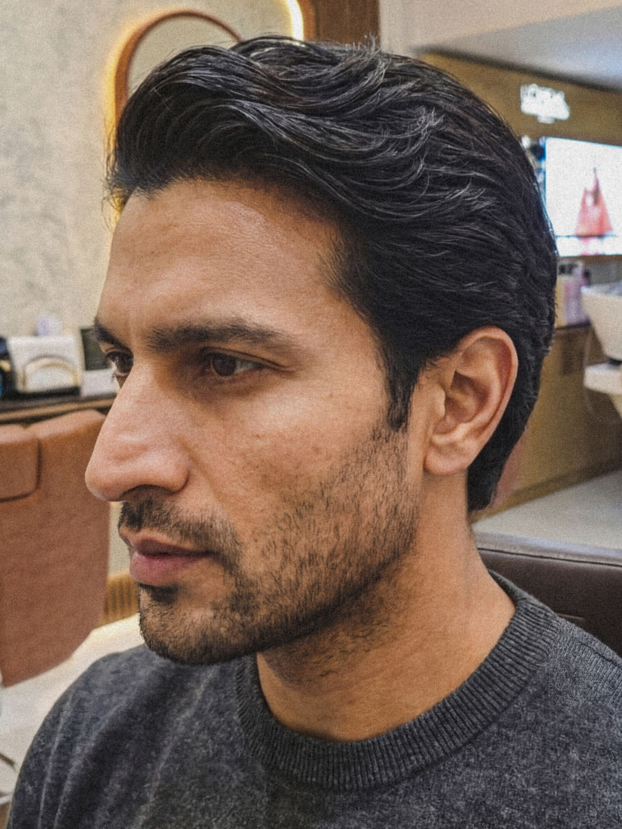 After: the same man in profile, hair cut short and swept back with a defined side profile, beard trimmed close.