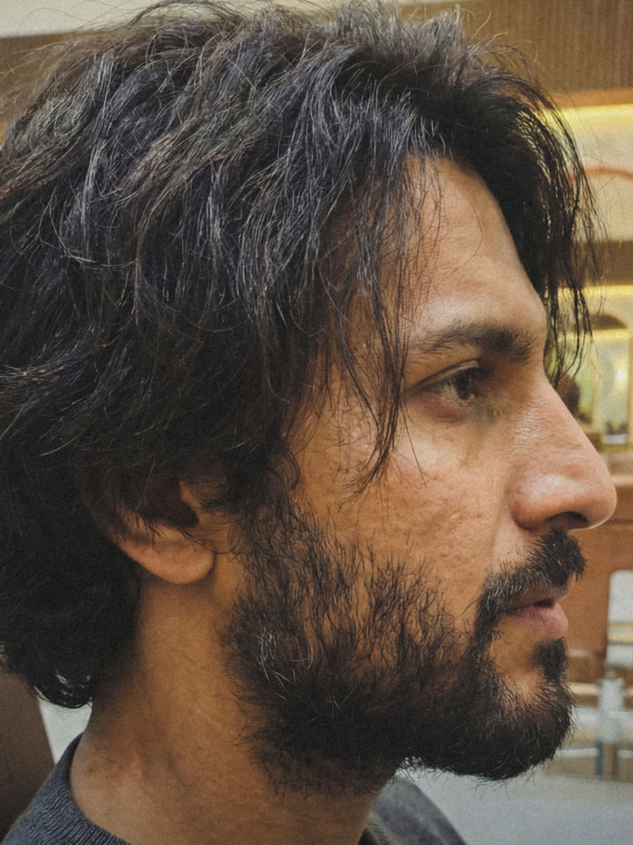 Before: a man in profile with long, unstyled hair grown past his collar and a full untrimmed beard.